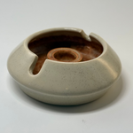 Designer ashtray with sculptural curves in cream and brown, crafted for high-end home interiors and office display.
