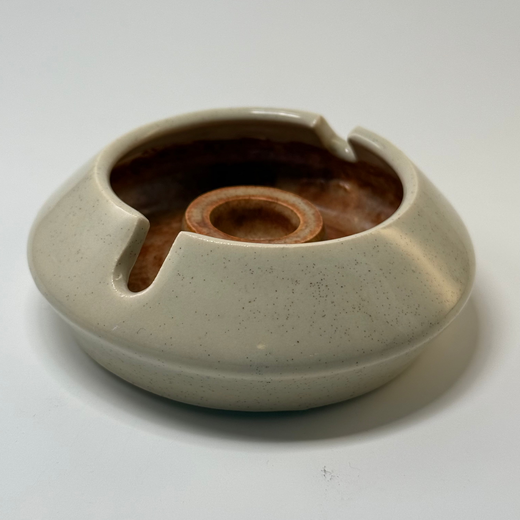 Designer ashtray with sculptural curves in cream and brown, crafted for high-end home interiors and office display.