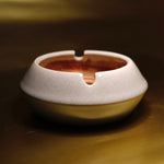 A refined cream and brown sculptural ashtray that enhances the aesthetic of coffee tables, bookshelves, and modern interior spaces.