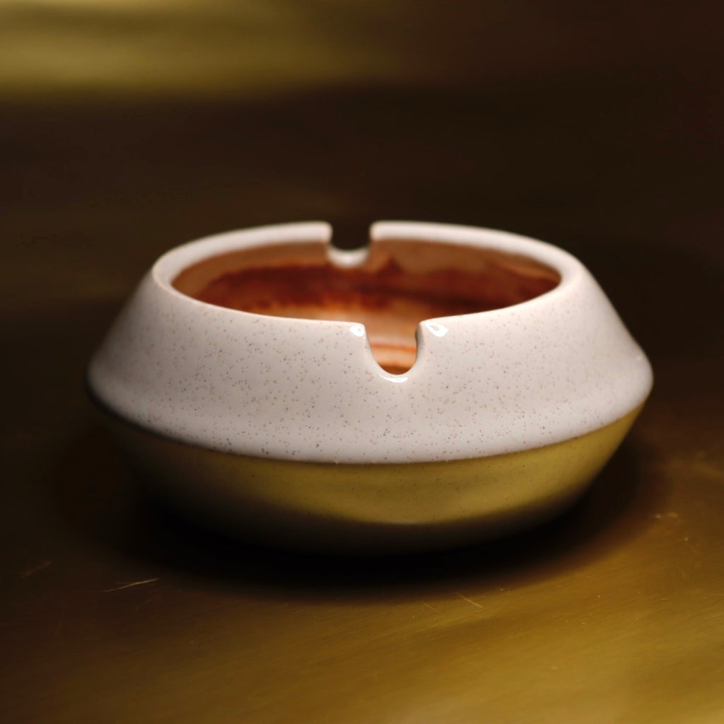 A refined cream and brown sculptural ashtray that enhances the aesthetic of coffee tables, bookshelves, and modern interior spaces.