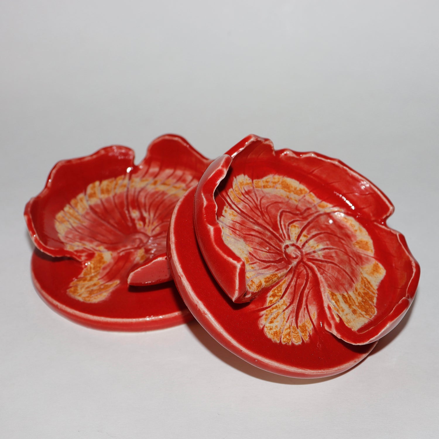 Red ceramic spoon rest  with floral design on a white background